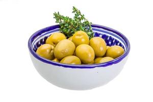 olives géantes vertes dans un bol sur fond blanc photo