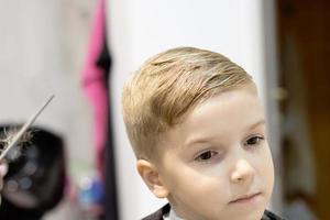 enfant mignon après la coupe de cheveux chez le coiffeur. photo