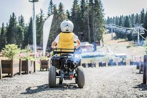 vue arrière d'un enfant conduisant un quad sur une piste hors route. photo