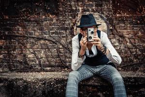 homme de style rétro filmant avec une vieille caméra vidéo 8 mm. photo