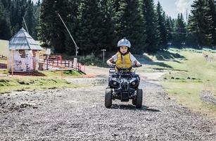 garçon qualifié conduisant un quad quad sur une piste hors route. photo