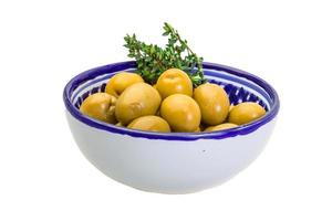 olives géantes vertes dans un bol sur fond blanc photo