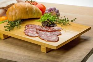 salami sur plaque de bois photo