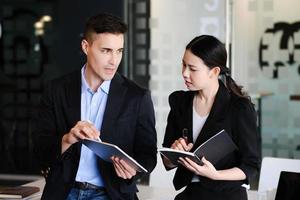 lors de la consultation, un conseiller masculin utilise un stylo pour pointer vers une tablette pour expliquer la restructuration des bénéfices aux femmes propriétaires d'entreprise. photo