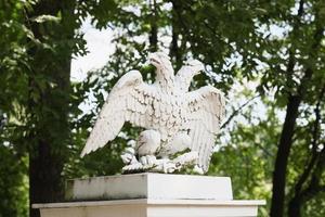 une statue en pierre d'aigle à deux têtes, symbole de la fédération de russie. l'élément architectural du décor de jardin. photo