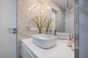 robinet d'eau en métal avec évier et robinet pour ouvrir et réguler l'eau froide ou chaude dans une salle de bain chère. photo