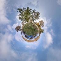 petite planète transformation du panorama sphérique à 360 degrés. vue aérienne abstraite sphérique dans une chênaie avec des branches maladroites en automne doré. courbure de l'espace. photo