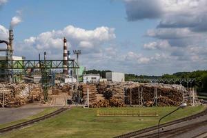 tuyaux de la scierie de l'usine de menuiserie près de la rivière. notion de pollution atmosphérique. paysage industriel pollution environnementale déchets de centrale thermique photo