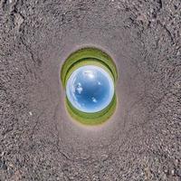 inversion de la transformation de la petite planète du panorama sphérique à 360 degrés. vue aérienne abstraite sphérique sur le terrain avec de beaux nuages impressionnants. courbure de l'espace. photo