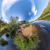 inversion de la transformation de la petite planète du panorama sphérique à 360 degrés. vue aérienne abstraite sphérique sur le terrain avec de beaux nuages impressionnants. courbure de l'espace. photo