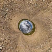 inversion de la petite planète bleue transformation du panorama sphérique à 360 degrés. vue aérienne abstraite sphérique sur le terrain avec de beaux nuages impressionnants. courbure de l'espace. photo