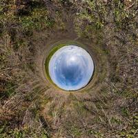 sphère bleue petite planète à l'intérieur de l'arrière-plan du cadre rond de l'herbe verte. photo