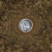 sphère bleue petite planète à l'intérieur de l'arrière-plan du cadre rond de l'herbe verte. photo