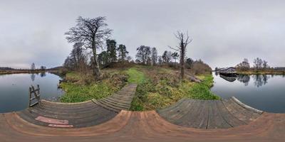 panorama hdri sphérique complet vue d'angle à 360 degrés sur la jetée en bois dans le lac près de l'ancien débarcadère abandonné en projection équirectangulaire avec zénith, prêt vr ar contenu de réalité virtuelle photo