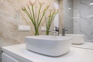 robinet d'eau en métal avec évier et robinet pour ouvrir et réguler l'eau froide ou chaude dans une salle de bain chère. photo