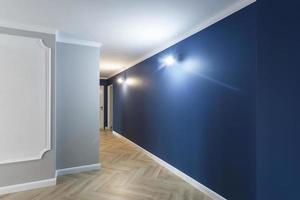 couloir vide non meublé avec des réparations préparatoires minimales avec moulures. intérieur de murs blancs et bleus photo