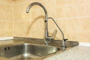 évier de robinet d'eau avec robinet dans une salle de bain ou une cuisine loft chère. photo