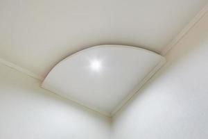 détail du plafond d'angle avec moulures complexes. plafond suspendu et construction de cloisons sèches dans une pièce vide d'un appartement ou d'une maison. plafond tendu de forme blanche et complexe. photo