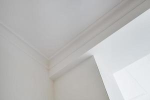coin du plafond et des murs avec moulures complexes. concept de construction et de rénovation intérieure. photo