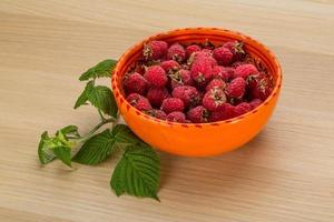 Framboise dans un bol sur fond de bois photo