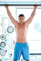 beau jeune homme travaillant dans une salle de sport photo