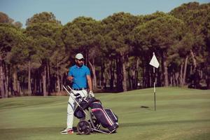 joueur de golf marchant avec un sac à roulettes photo