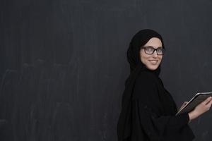 jeune femme d'affaires arabe en vêtements traditionnels ou abaya tenant une tablette photo