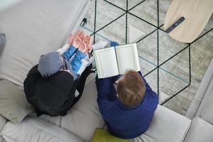 vue de dessus d'une jeune famille musulmane lisant le coran pendant le ramadan photo