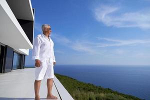 homme âgé devant une maison moderne photo