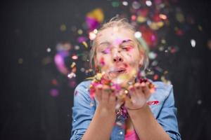 femme soufflant des confettis dans l'air photo