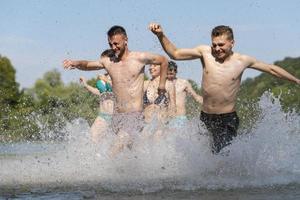 groupe d'amis heureux s'amusant sur la rivière photo