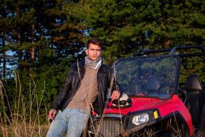 jeune homme prenant une pause dans la conduite d'une voiture buggy hors route photo