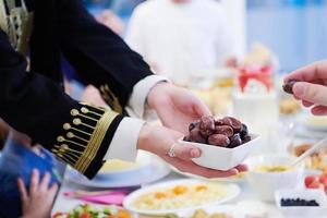 famille musulmane dînant à l'iftar mangeant des dattes pour rompre le festin photo