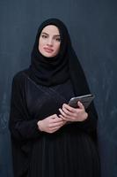 jeune femme d'affaires musulmane moderne à l'aide d'une tablette photo