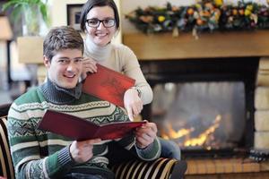 jeune couple romantique assis et relaxant devant la cheminée à la maison photo