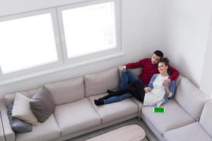 jeune couple sur le canapé devant la télévision photo