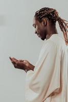 beau jeune homme musulman africain faisant la prière fatiha traditionnelle à allah dieu tout en portant un vêtement de mode soudan traditionnel en studio photo