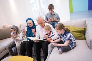 grands-parents musulmans modernes avec petits-enfants lisant le coran photo