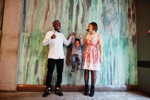 une famille multiethnique heureuse avec un garçon passe du temps au restaurant. relations de l'homme africain et de la femme européenne blanche. photo
