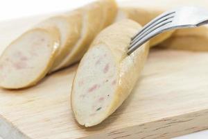 saucisse sur une fourchette et une planche à découper photo