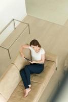 femme sur un canapé à l'aide d'une tablette photo