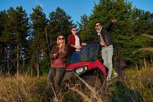 groupe de jeunes gens heureux profitant d'une belle journée ensoleillée tout en conduisant une voiture buggy hors route photo