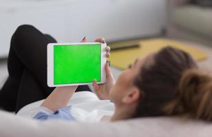 femme sur un canapé à l'aide d'une tablette photo