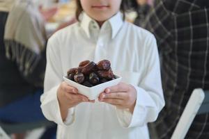 enfant arabe dans les vêtements traditionnels pendant l'iftar photo