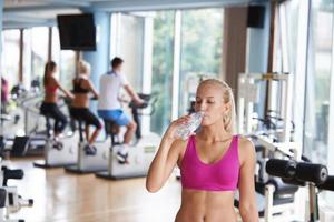 femme dans la salle de fitness boire de l'eau photo