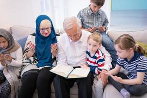 grands-parents musulmans modernes avec petits-enfants lisant le coran photo