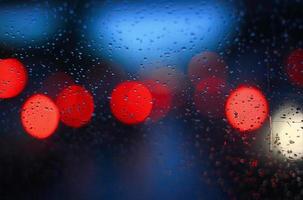 lumière bokeh colorée de gouttes de pluie sur la vitre de la voiture. photo