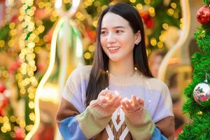 jeune femme asiatique qui a de longs cheveux beau sourire tenant une petite ampoule dans le thème de la célébration du nouvel an, thème du bonheur. photo