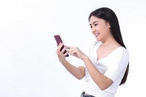 portrait d'une belle femme asiatique utilise le téléphone portable avec bonheur sur fond blanc. photo