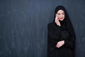 jeune femme d'affaires musulmane moderne utilisant un smartphone photo